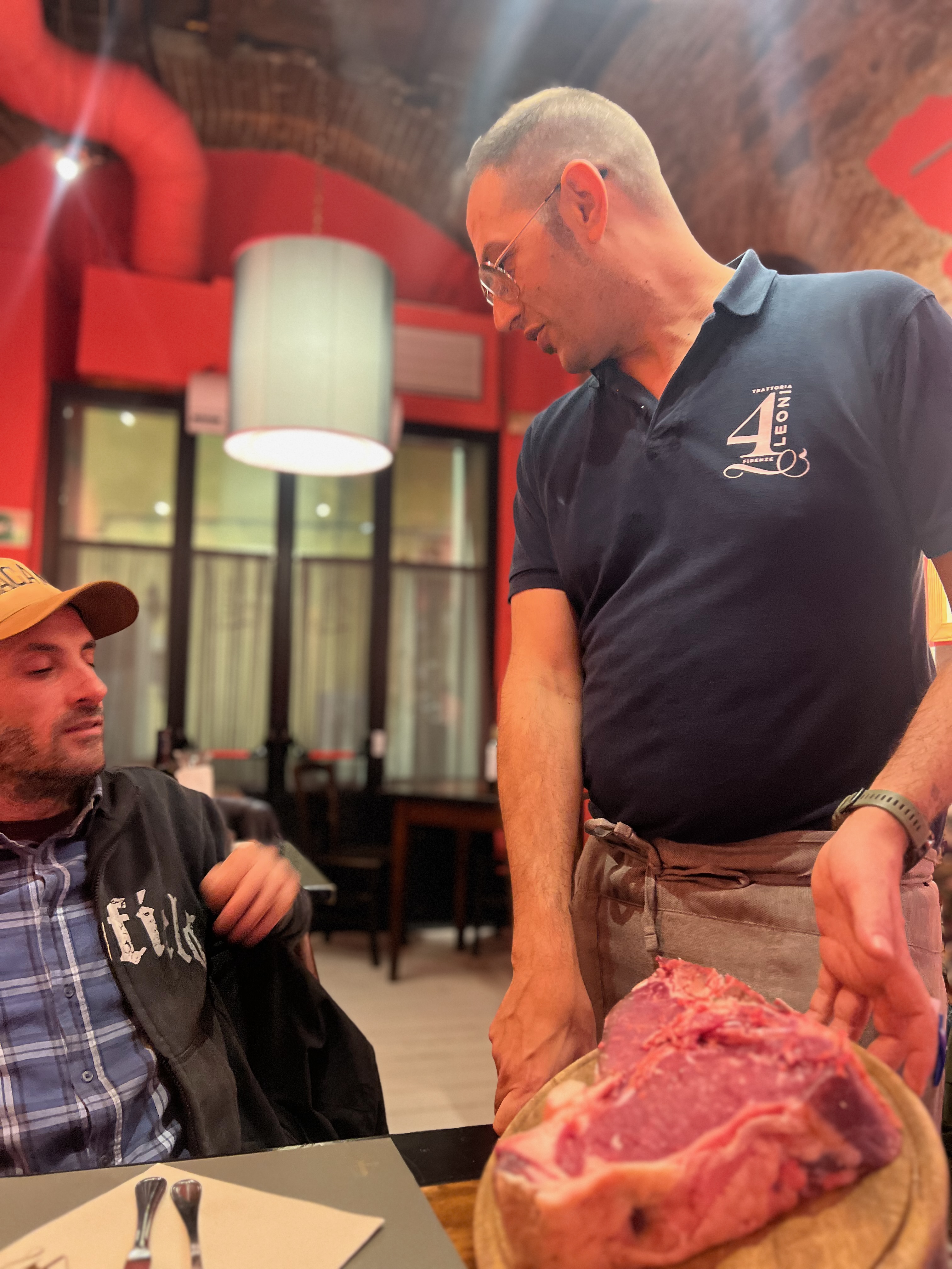 Camarero presentando una bistecca alla fiorentina en la mesa