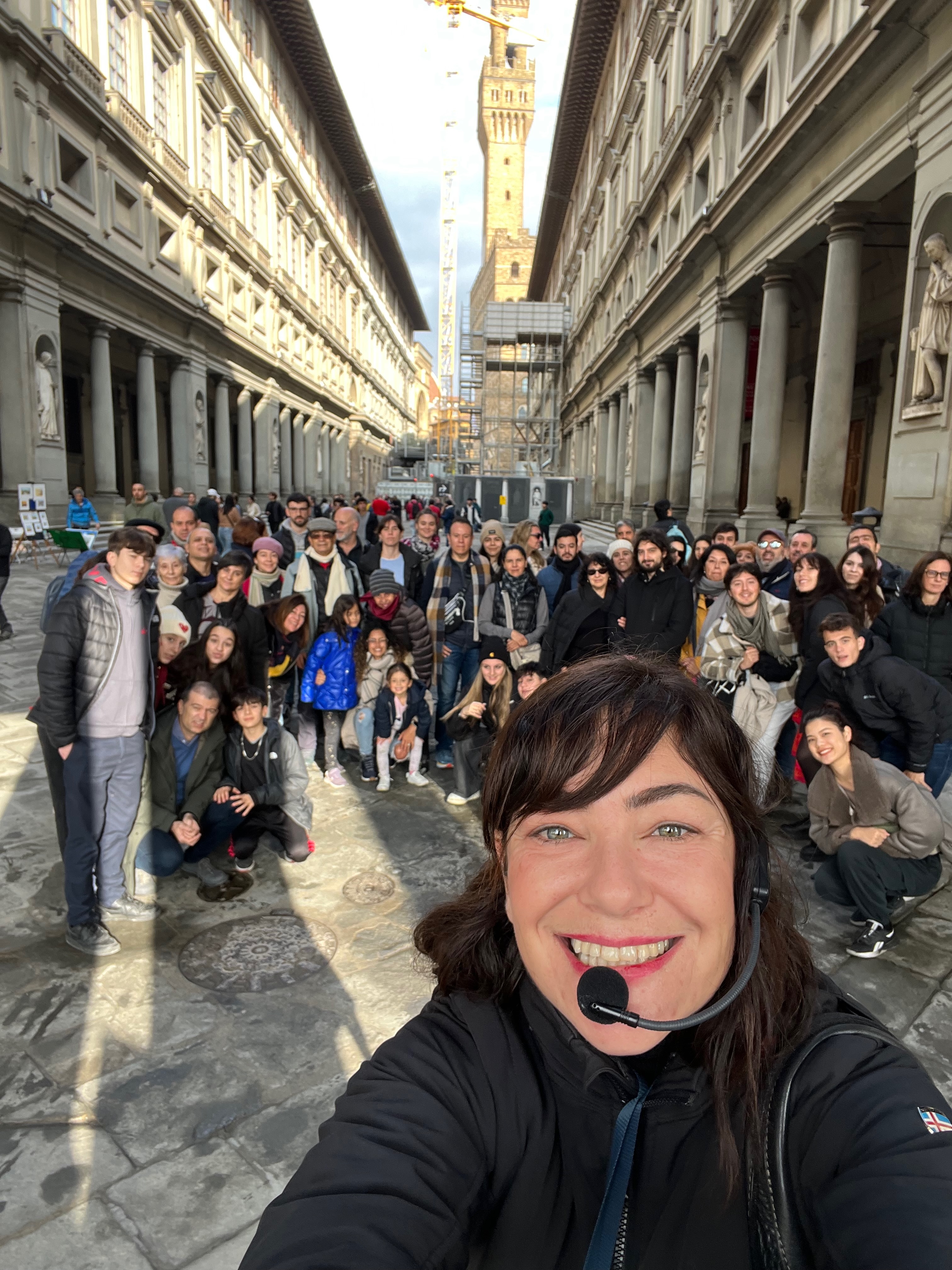 Chiara Reale sonriendo con su grupo en el patio de los Uffizi